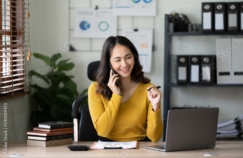 Woman working on the mobile phone in the office