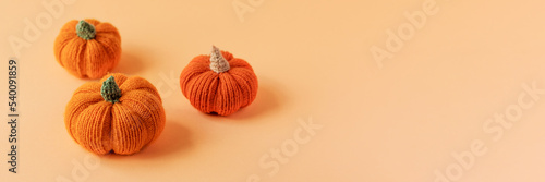 Knitted orange pumpkins on an orange background, autumn composition. Halloween concept.