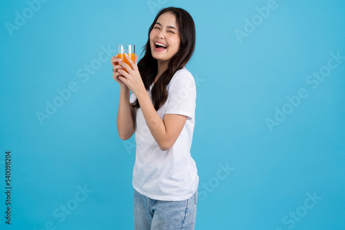 Beautiful woman drinking orange from a glass.