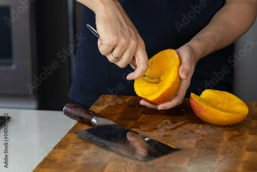 Chef cook cutting fresh mango for fruit salad on wooden cut board