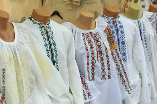 Moldovan embroideries. Men's and women's Moldovan embroidered shirts at the fair. Balkan embroidered national traditional costume clothes