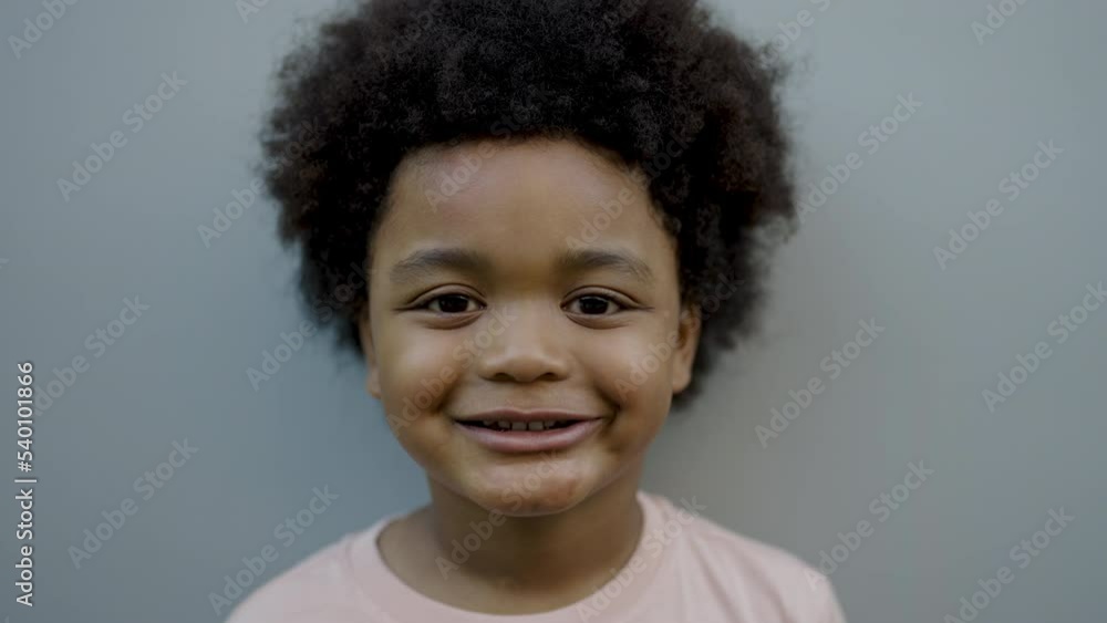 Fun in the spring park. Portrait of young happy little afro black boy stand on green grass background. Education back to school spend leisure time in nature forest, authentic concept Fun in the spring park. Portrait of young happy little afro black boy stand on green grass background. Education back to school spend leisure time in nature forest, authentic concept