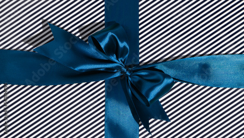 Φωτογραφία Blue gift ribbon and bow on black and white wrapping paper