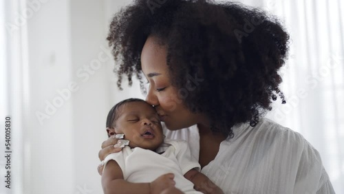 Close up portrait of beautiful young African American mother holding kissing sleep newborn baby in hospital. Healthcare medical love black afro woman lifestyle mother's day, breast concept 