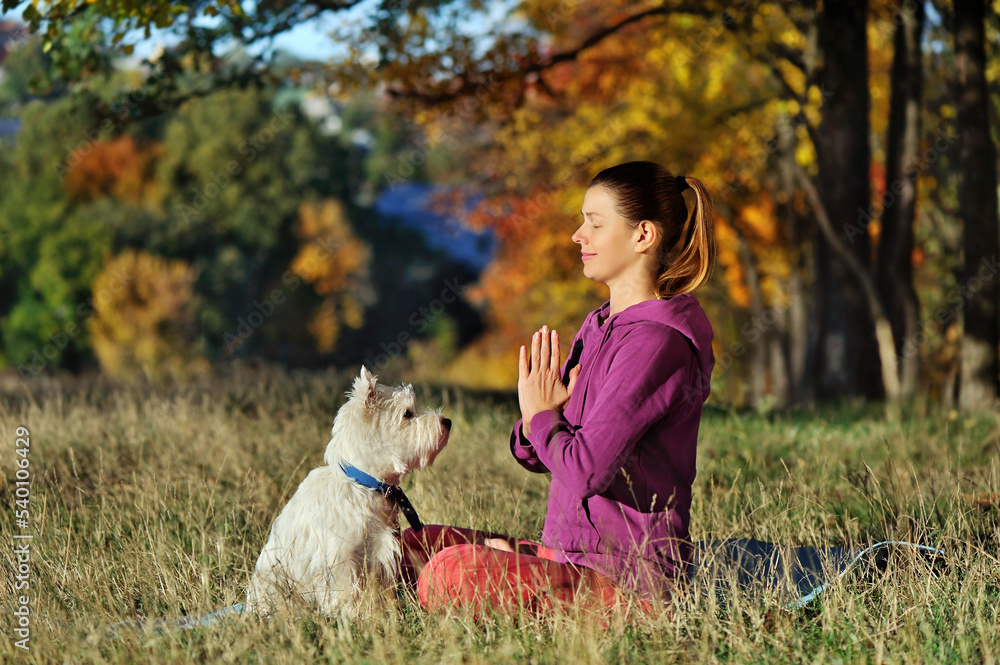 Side view of woman meditati in the forest with her dog Side view of woman meditati in the forest with her dog