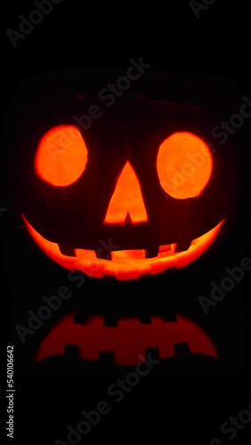 Close-up on a Jack O Lantern glowing in the dark for a perfect Halloween. photo