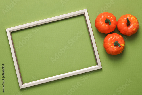 Halloween plastic decorative pumpkins with golden frame on four tone green background. Trick or treat. Top view