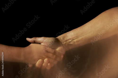 adult and child shaking hands with motion trails on dark background