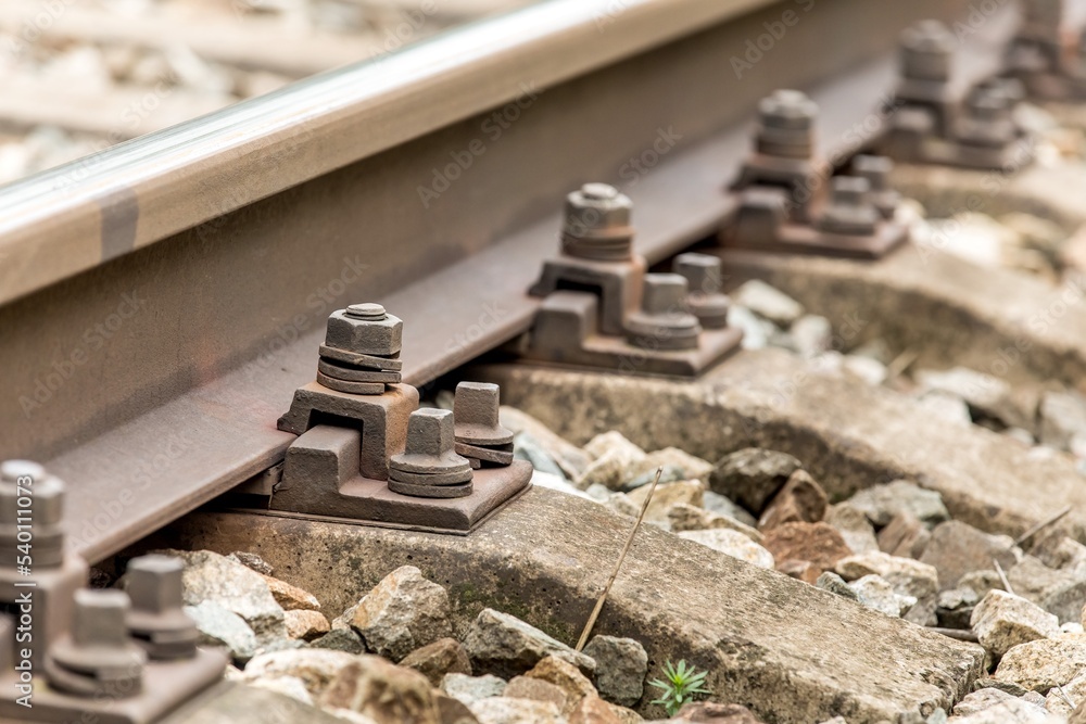 Railway track bolts. Detail of rusty screws and nut on railroad track. Rusty screws and nut on old railroad track. Concrete tie with rusty nuts and bolts. Railway track bolts. Detail of rusty screws and nut on railroad track. Rusty screws and nut on old railroad track. Concrete tie with rusty nuts and bolts.