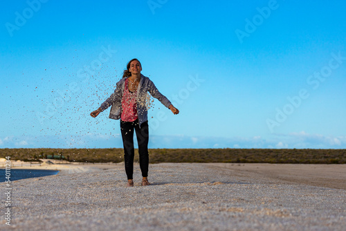 A beautiful girl plays with seashells on the famous shell beach in western australia, sunset on shell beach in francois peron national park © Jakub