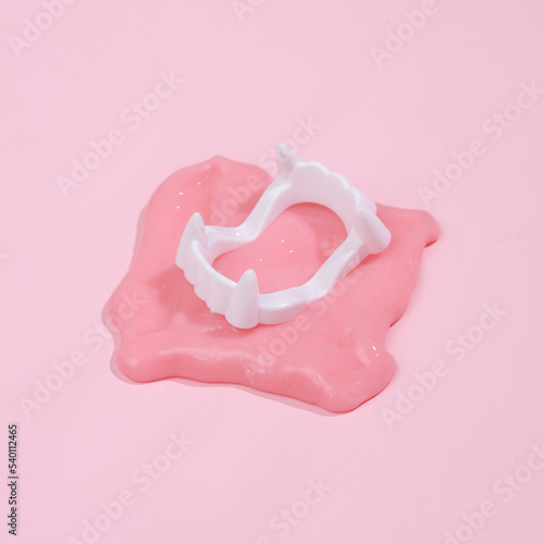 Creative Halloween layout, vampire jaw with slime on pink background with shadow. Visual trend. Fresh idea. Concept pop