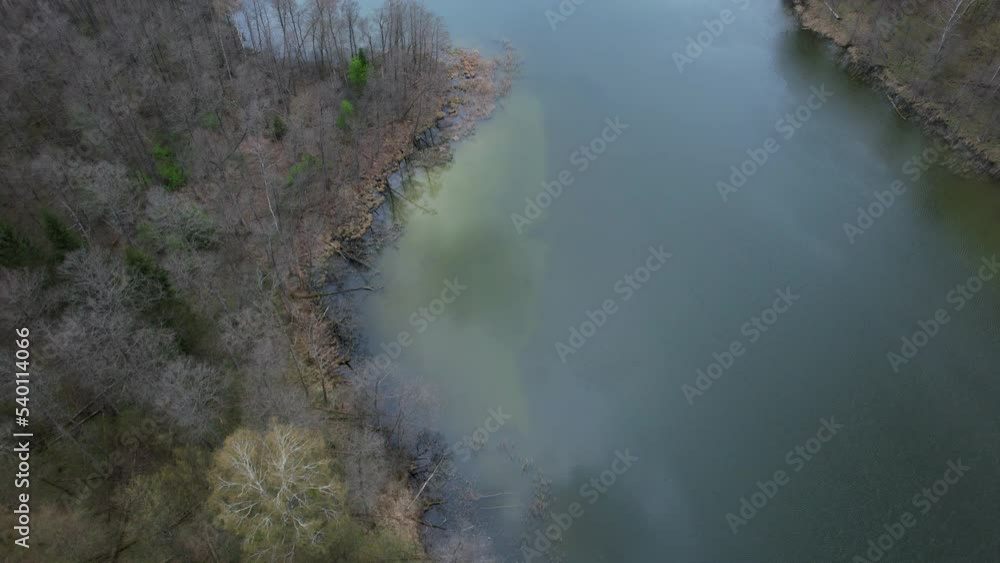 Aerial view of the lake and forest during early spring season. Flight over the water. Couple in a kayak. Aerial view of the lake and forest during early spring season. Flight over the water. Couple in a kayak.