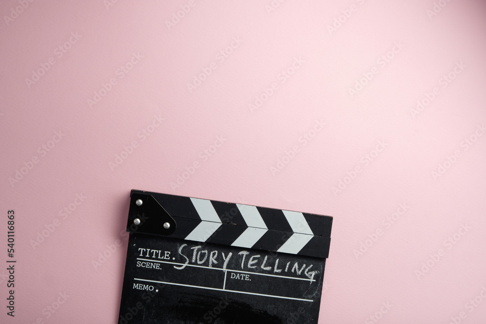 story telling textr on clapper borad against pink background