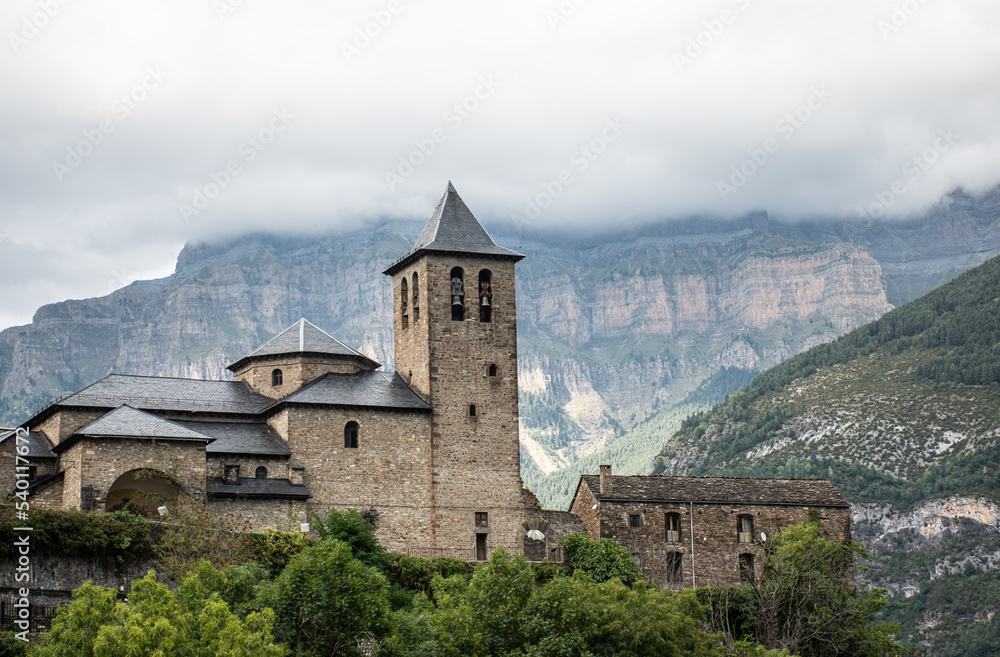 Church of San Salvador in Torla - Ordesa, with Monte Perdido in the background on a foggy day. Pyrenees