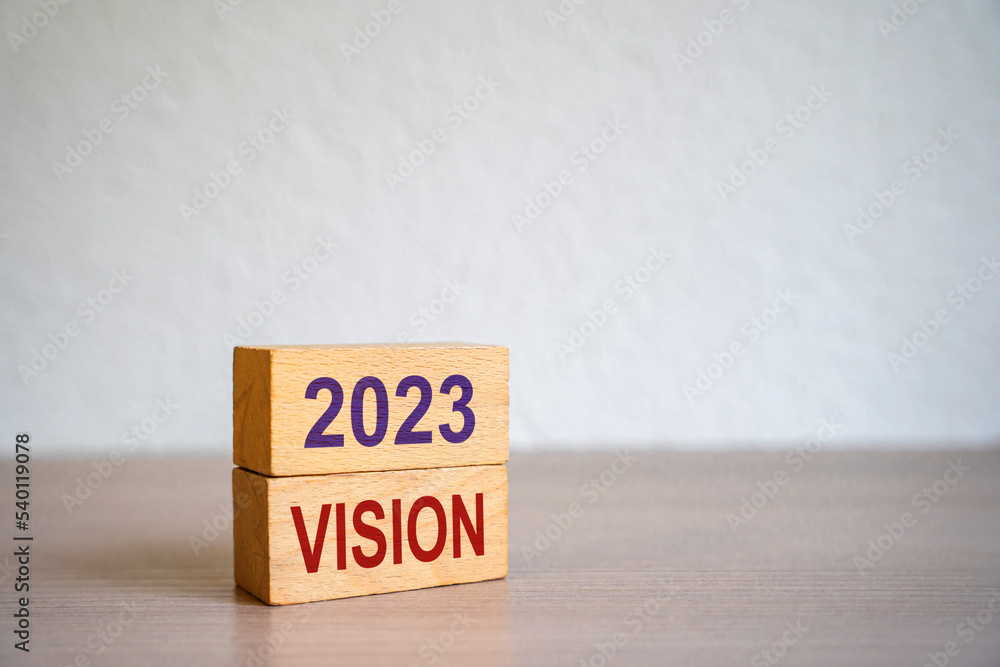 Hand puts blocks with the words 2023 Vision. Concept for business ideas and goals. Strategy development. Planning and action plan. Performance, motivation and company management. Hand puts blocks with the words 2023 Vision. Concept for business ideas and goals. Strategy development. Planning and action plan. Performance, motivation and company management.