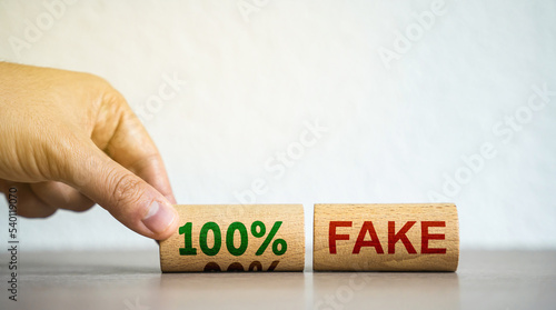 Slika na platnu Hand puts blocks with the words 100% fake