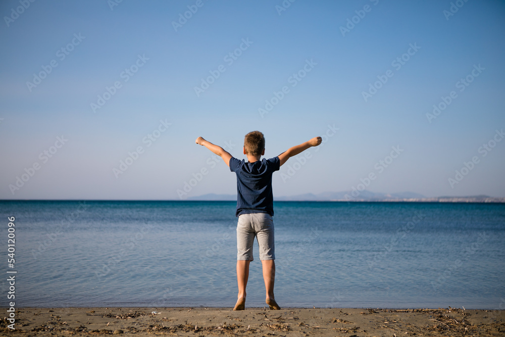 Boy playing on the beach on summer holidays. Children in nature with beautiful sea, sand and blue running in the sea water. Boy playing on the beach on summer holidays. Children in nature with beautiful sea, sand and blue running in the sea water.