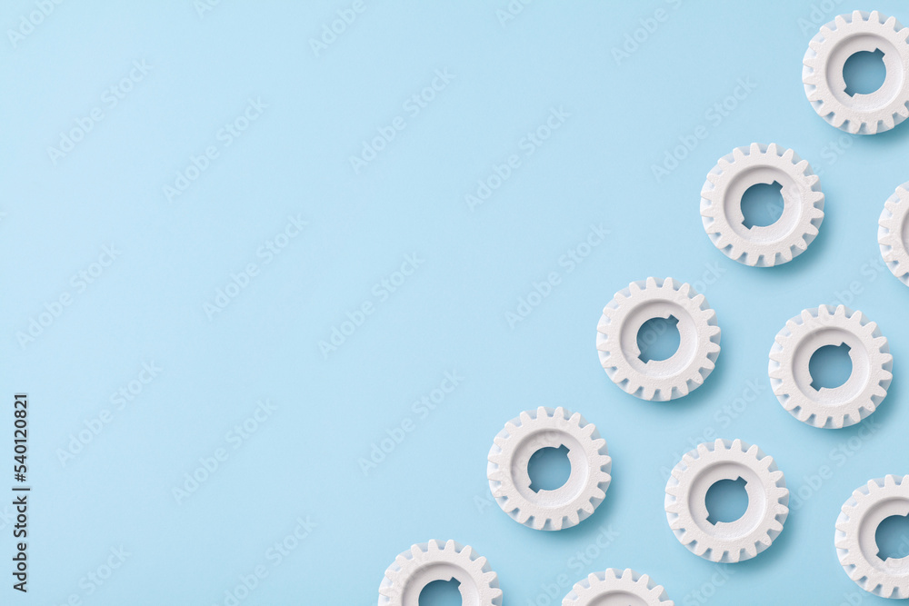Flat lay white gears wheels symbolizing idea, cooperation, teamwork and connection concept