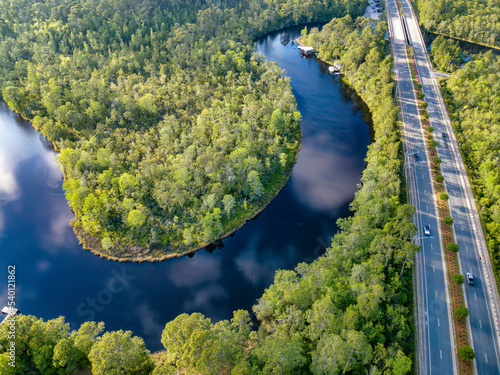 East Bay River flowing along the lush forest and roads in Navarre Florida