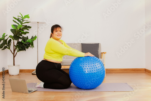 Portrait cute healthy fat asian woman wants to lose weight too fat exercise with gym ball play sports at home yoga healthy lifestyle and relaxation : Health care concept. photo