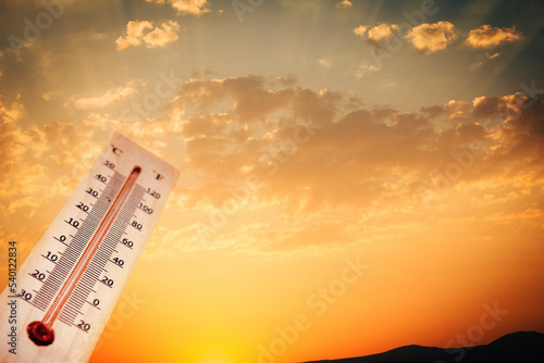 hot temperature, thermometer on yellow sky with shining summer sun