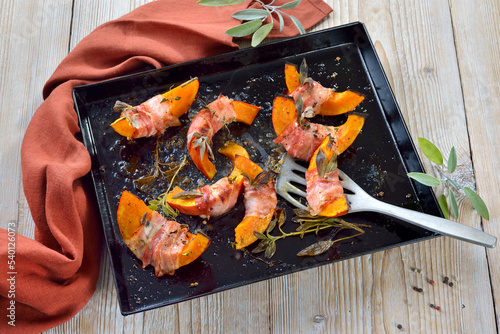 Hokkaido-Kürbisschnitten im Salbei-Speckmantel aus dem Ofen – Pumpkin gaps wrapped in bacon with sage leaves and thyme, baked in olive oil with pepper and salt
