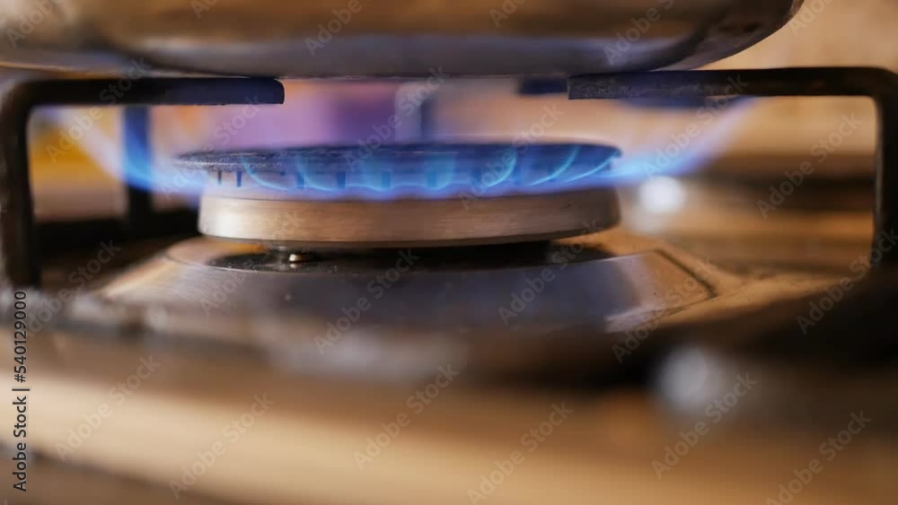 the turned on burner of the gas stove burns with a blue fire close-up and the fire goes out. Gasification of residential premises for domestic needs. Gas situation in the world the turned on burner of the gas stove burns with a blue fire close-up and the fire goes out. Gasification of residential premises for domestic needs. Gas situation in the world