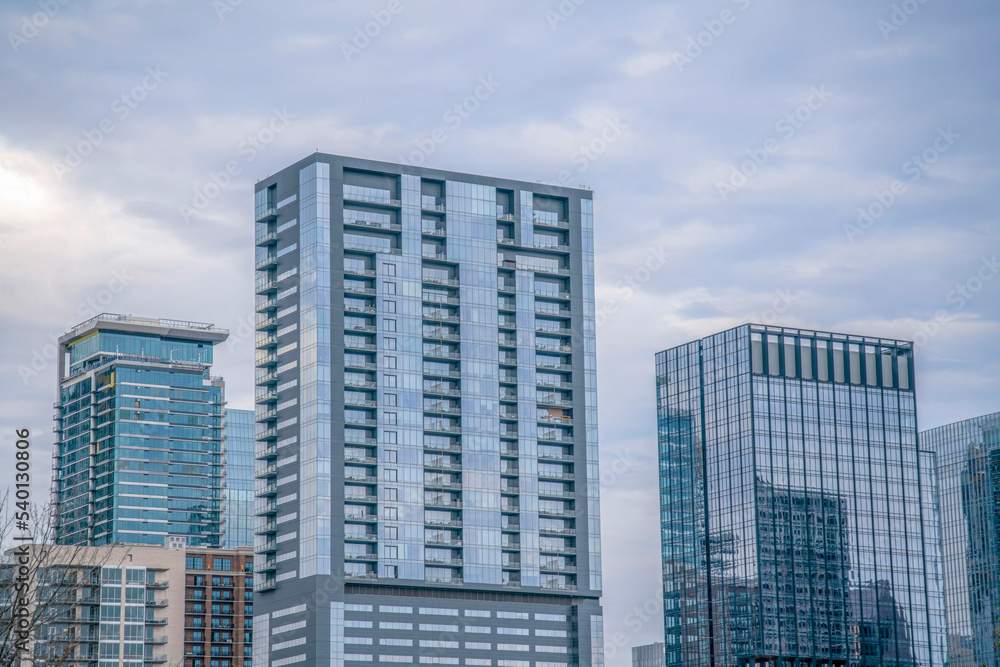 Naklejka premium Buildings with reflective glass windows in downtown Austin Texas on a cloudy day