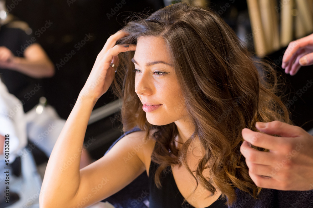 Fototapeta premium Young woman getting new hairstyle from hairdresser in the modern hair salon