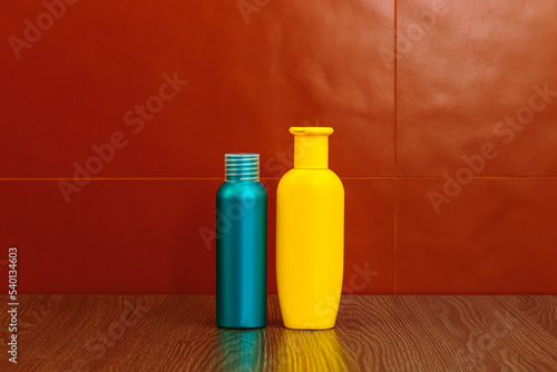 Containers and bottles of different sizes, shapes and colors for cleanser, tonic, conditioner, soap and shampoo on a red background in the bathroom. Natural organic cosmetics, packaging with an empty.