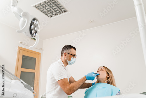 Doctor inserts impression tray and making cast of teeth to patient in dentistry before dental implantation. Procedure of creating dental prostheses, crowns and aligners. photo