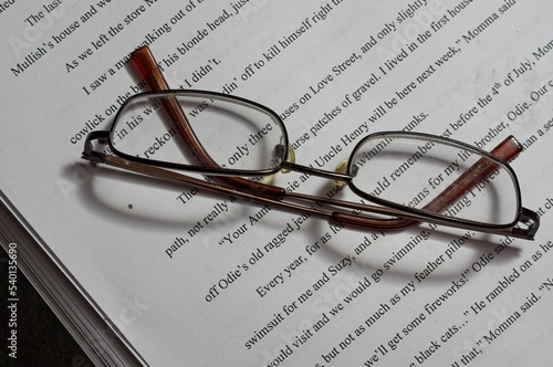 Reading glasses on top of a novel manuscript