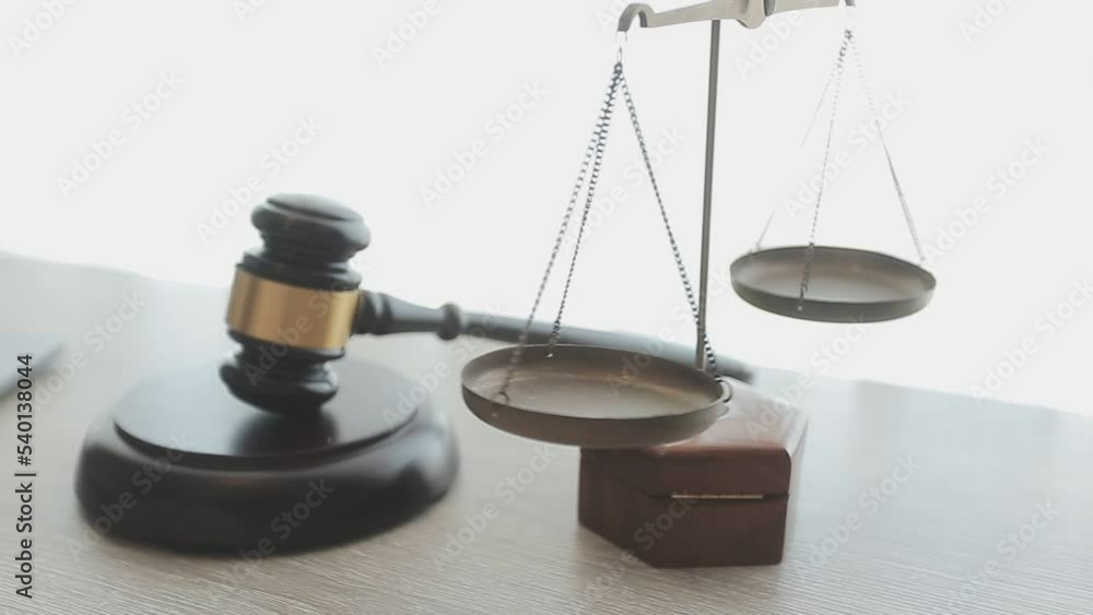 Business and lawyers discussing contract papers with brass scale on desk in office. Law, legal services, advice, justice and law concept Business and lawyers discussing contract papers with brass scale on desk in office. Law, legal services, advice, justice and law concept