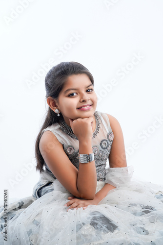 Cute indian little girl in ethnic wear and showing expression over white background