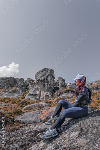 Mujer latina sentada apuntando las montañas 