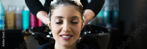 Hairdresser washing hair of the woman in modern hair salon