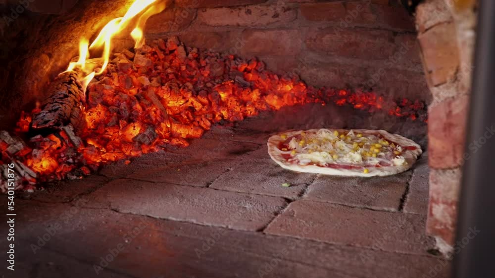 Sliding Pizza While Being Baked on Oven. Baker is using shovel to move