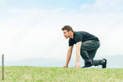 公園で短距離走・全速力で走る練習をするスポーツウェアを着た陸上選手の白人男性 