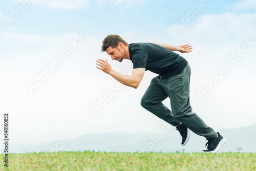 公園でスタートダッシュの練習をするスポーツウェアを着た陸上選手の白人男性 