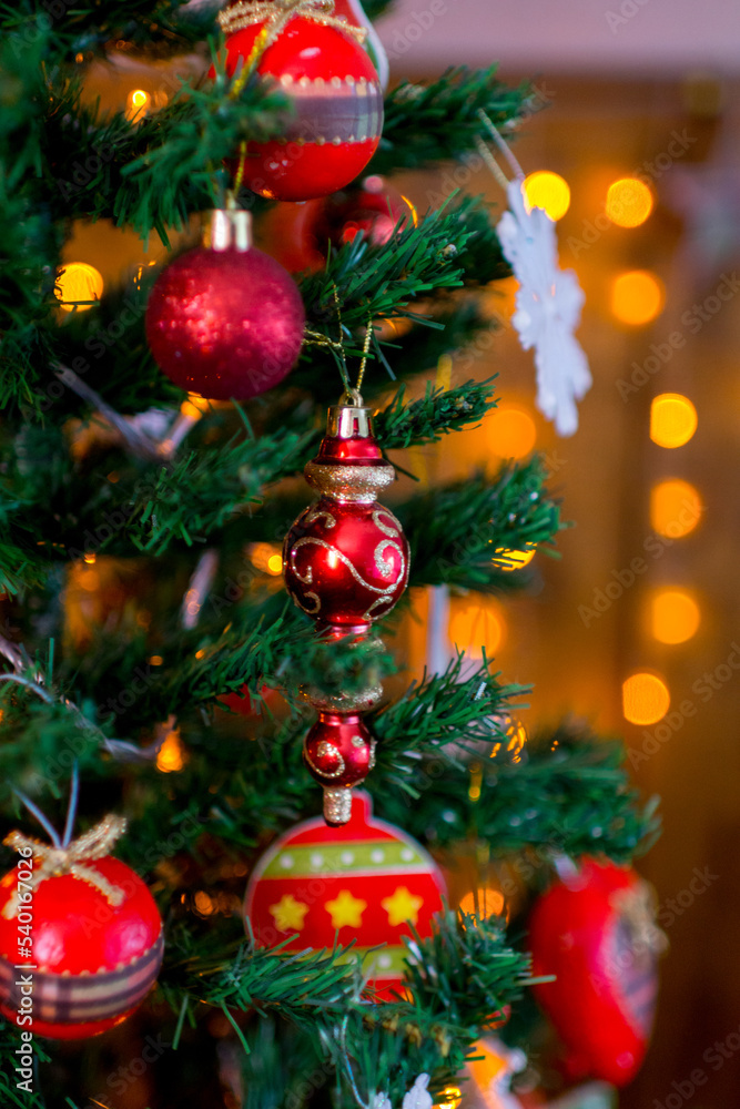 A variety of red decorations on a green Christmas tree.