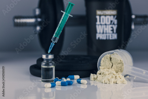 dumbbell, syringe with needle, pills and vial with steroids and whey powder in scoop. illegal doping in sport concept. loss weigh or build muscle. 