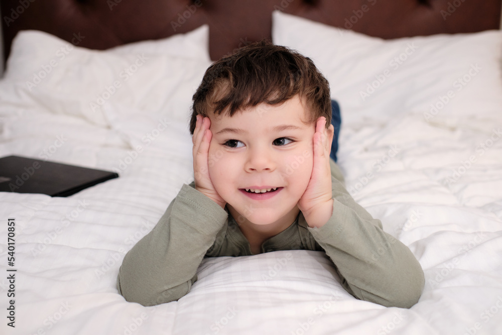 cute young boy on the bed in the hotel room