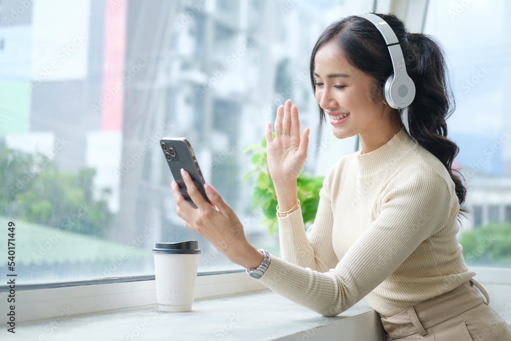 Smiling young woman having video call on mobile phone and enjoying pleasant conversation. Smiling young woman having video call on mobile phone and enjoying pleasant conversation.
