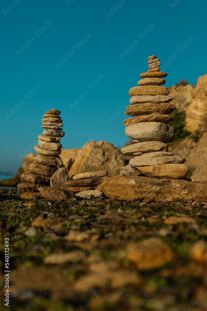 Laying beach stones balancing rocks on a sand seashore