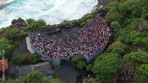 Drone footage of Ulluwatu Temple and audience watching Kecak Dance during sunset photo