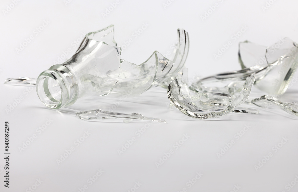 Broken glass bottle. Sharp shards of clear glass. Broken glass bottle. Sharp shards of clear glass.