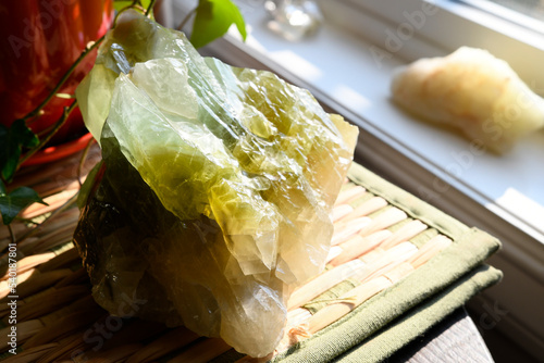 An image of a large green calcite crystal in bright sun light. photo