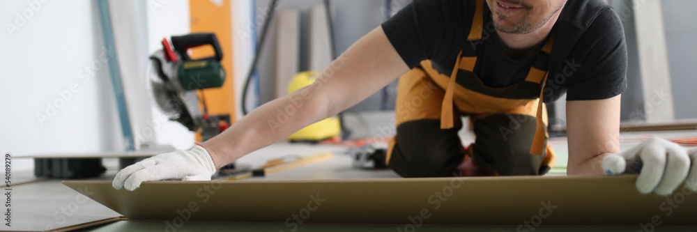 Handyman set wooden panel of laminate floor, installing floor in flat Handyman set wooden panel of laminate floor, installing floor in flat