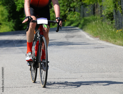 Fototapeta Naklejka Na Ścianę i Meble -  cyclist with bike rides fast on the asphalt road