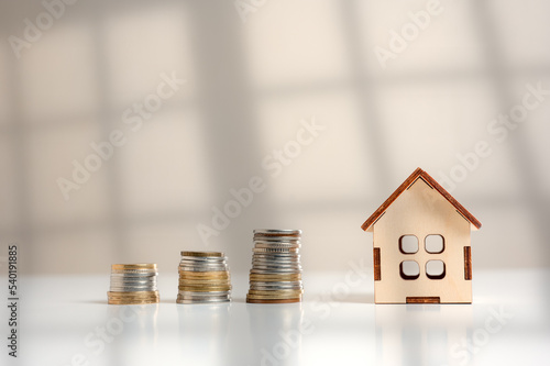 Fotografie House, property or real estate market price go up or rising concept, small miniature house and Stacked coins